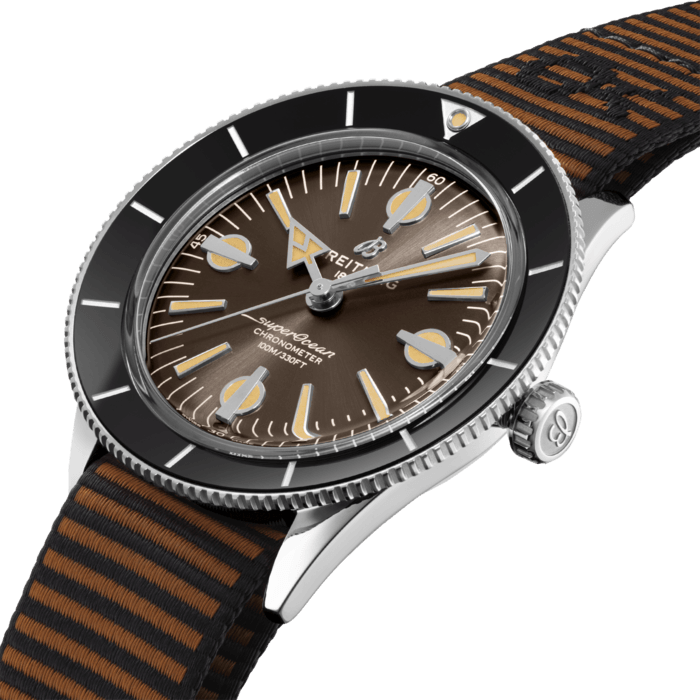 The Superocean Heritage ’57 Outerknown pays tribute to the original 1957 SuperOcean and the cool, laid-back surfing lifestyle of the 1960s. Co-designed with Kelly Slater’s surf wear brand, it features a special ECONYL® yarn single-piece strap, repurposed from nylon waste pulled out from the oceans, like fishing nets.
Available in stainless steel, the 42 mm case features two signature elements of the original SuperOcean: a concave bidirectional ceramic bezel and a dial featuring oversized indices. Codesigned with Kelly Slater’s surf wear brand, the Superocean Heritage ’57 Outerknown is paired with a brown Outerknown single-piece strap crafted from ECONYL® yarn. The Superocean Heritage ’57 Outerknown is powered by the Breitling Caliber 10, a COSC-certified chronometer.