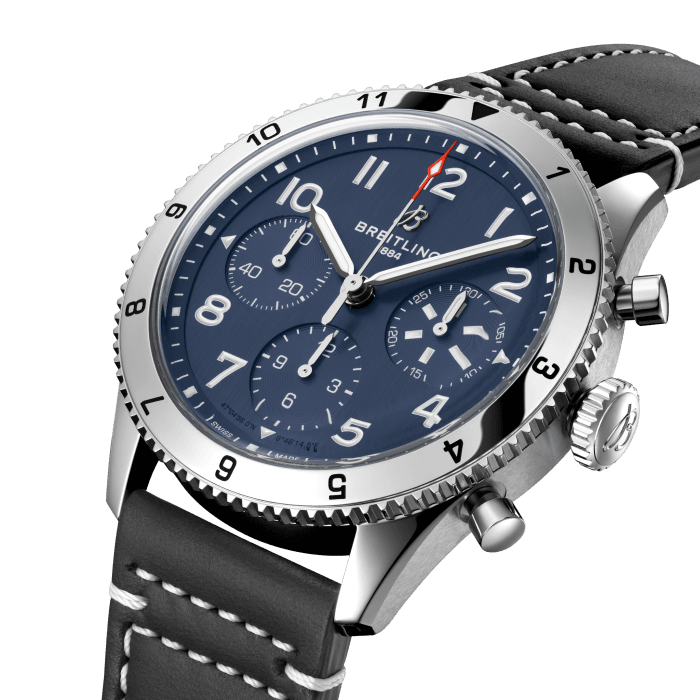From brave first takeoffs to the birth of commercial air travel, Breitling’s history is inseparable from that of flight. In the 1930s, Breitling’s Huit Aviation department made its name inventing precision cockpit clocks. Two decades later, it introduced yet another novel flight instrument, this time in wearable form: the Ref. 765 AVI. That pioneering pilot’s watch provided the technical backdrop for today’s Classic AVI, a collection inspired by the rugged spirit of famed early aircraft.
The Classic AVI Tribute to Vought F4U Corsair honors one of those legends. As a WWII naval aircraft, the Vought F4U Corsair had to make tricky takeoffs and landings from carriers and remote landing strips. Speed and lift were of the essence, and the plane came through with flying colors, becoming the first single-engine fighter to crack the 400 mph (640 km/h) mark, while also providing an exceptional rate of climb. Its “bent-wing” design, oversized propeller and signature blue livery make it an emblem of aviation history.
As a true pilot’s watch designed to withstand the rigors of a vintage cockpit, the Classic AVI Tribute to Vought F4U Corsair features large, highly legible Arabic numerals on the dial and bezel.
The knurled bezel on the 42mm case provides optimal grip, even in a pilot’s gloved hands. Top-stitched calfskin straps give a nod to the seams found on classic flight gear, while the stainless-steel bracelet provides an elegant alternative. Pilots and other travelers will appreciate its legibility, wearability, and understated style. The engine of the Classic AVI is the COSC-certified Breitling Caliber 23 movement, which provides approximately 48-hours of power reserve.