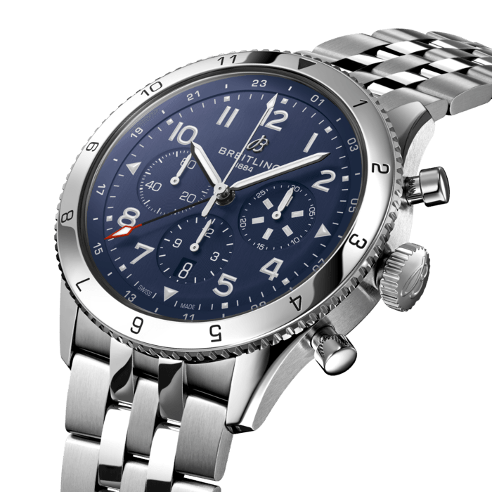 From brave first takeoffs to the birth of commercial air travel, Breitling’s history is inseparable from that of flight. In the 1930s, Breitling’s Huit Aviation department made its name inventing precision cockpit clocks. Two decades later, it introduced yet another novel flight instrument, this time in wearable form: the Ref. 765 AVI. That pioneering pilot’s watch provided the technical backdrop for today’s Super AVI, a collection inspired by the rugged spirit of famed early aircraft.
The Super AVI Tribute to Vought F4U Corsair honors one of those legends. As a WWII naval aircraft, the Corsair had to make tricky takeoffs and landings from carriers and remote landing strips. Speed and lift were of the essence, and the plane came through with flying colors, becoming the first single-engine fighter to crack the 400 mph (640 km/h) mark, while also providing an exceptional rate of climb. Its “bent-wing” design, oversized propeller and signature blue livery make it an emblem of aviation history.
As a true pilot’s watch designed to withstand the rigors of a vintage cockpit, the Super AVI Tribute to Vought F4U Corsair features large, highly legible Arabic numerals on the dial and bezel.
The oversized crown and knurled bezel on its sturdy 46mm case provide optimal grip, even in a pilot’s gloved hands. Top-stitched calfskin straps give a nod to the seams found on classic flight gear, while the optional stainless-steel bracelet provides an elegant alternative. Pilots and other travelers will appreciate the ability to track a second time zone using the 24-hour marking on the inner bezel and the red-tipped GMT hand. The engine of the Super AVI is the COSC-certified Breitling Manufacture Caliber B04 movement, which provides approximately 70-hours of power reserve.