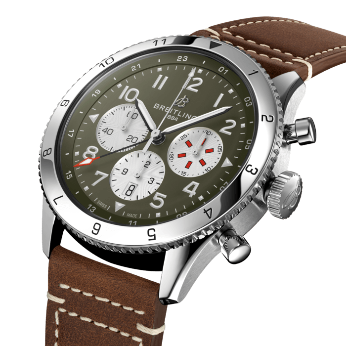 From brave first takeoffs to the birth of commercial air travel, Breitling’s history is inseparable from that of flight. In the 1930s, Breitling’s Huit Aviation department made its name inventing precision cockpit clocks. Two decades later, it introduced yet another novel flight instrument, this time in wearable form: the Ref. 765 AVI. That pioneering pilot’s watch provided the technical backdrop for today’s Super AVI, a collection inspired by the rugged spirit of famed early aircraft.
The Super AVI Curtiss P-40 Warhawk honors one of those legends. Conceived as a pursuit aircraft, the Curtiss P-40 Warhawk first flew in 1938 and quickly proved itself as a master of agility. It wasn’t just the plane’s capacity for pulling jaw-dropping turns that gave it an in-flight edge, its robust structure meant it could tolerate harsh weather conditions and even many mid-air collisions. The Warhawk’s defiant shark-mouth nose art sealed its reputation as the rebel of the skies.
As a true pilot’s watch designed to withstand the rigors of a vintage cockpit, the Super AVI Curtiss P-40 Warhawk features large, highly legible Arabic numerals on the dial and bezel.
The oversized crown and knurled bezel on its sturdy 46mm case provide optimal grip, even in a pilot’s gloved hands. Top-stitched calfskin straps give a nod to the seams found on classic flight gear, while the optional stainless-steel bracelet provides an elegant alternative. Pilots and other travelers will appreciate the ability to track a second time zone using the 24-hour marking on the inner bezel and the red-tipped GMT hand. The engine of the Super AVI is the COSC-certified Breitling Manufacture Caliber B04 movement, which provides approximately 70-hours of power reserve.