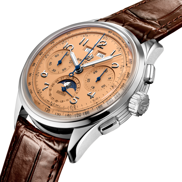 Paying homage to three generations of inventors – Léon, Gaston & Willy Breitling – the Premier Datora is the most refined Breitling chronograph with its complete calendar and moon-phase. As Willy Breitling said, the Premier is an “unmistakable stamp of impeccable taste”.
This latest generation of Premier chronographs brings its timeless elegance back to life, and showcases Breitling’s highest level of watchmaking thanks to a range of iconic Premier complications: the Chronograph, the Duograph and the Datora.
Featuring rectangular chronograph pushers and Arabic numerals, the heritage-revived Premier Datora displays a variety of elegant design details such as grooves on the case-sides, open sapphire casebacks and vintage-inspired hands.
The Datora comes in two variations: in stainless steel with a copper dial and a brown alligator strap or in 18k red gold with a silver dial and a brown alligator strap. “Datora” was a term used by Breitling in the 1940s and refers to a complete calendar chronograph displaying day, date, month and the different moon phases. The Datora is powered by the cosc-certified Manufacture Caliber B25.