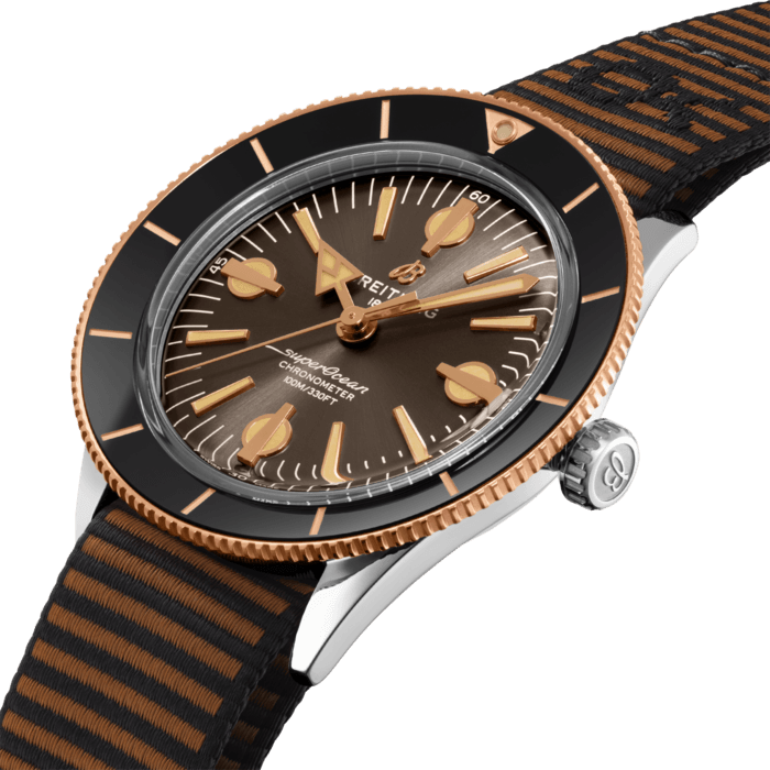 The Superocean Heritage ’57 Outerknown pays tribute to the original 1957 SuperOcean and the cool, laid-back surfing lifestyle of the 1960s. Co-designed with Kelly Slater’s surf wear brand, it features a special ECONYL® yarn single-piece strap, repurposed from nylon waste pulled out from the oceans, like fishing nets. Limited to 500 pieces.
Available in stainless steel and 18k red gold, the 42 mm case features two signature elements of the original SuperOcean: a concave bidirectional ceramic bezel and a dial featuring oversized indices. Codesigned with Kelly Slater’s surf wear brand, the Superocean Heritage ’57 Outerknown is paired with a brown Outerknown single-piece strap crafted from ECONYL® yarn. The Superocean Heritage ’57 Outerknown is powered by the Breitling Caliber 10, a COSC-certified chronometer.