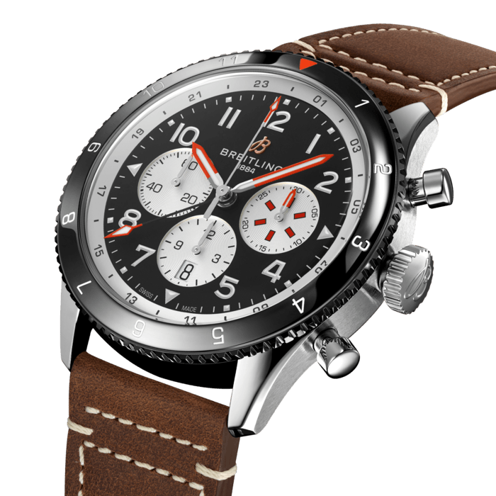 From brave first takeoffs to the birth of commercial air travel, Breitling’s history is inseparable from that of flight. In the 1930s, Breitling’s Huit Aviation department made its name inventing precision cockpit clocks. Two decades later, it introduced yet another novel flight instrument, this time in wearable form: the Ref. 765 AVI. That pioneering pilot’s watch provided the technical backdrop for today’s Super AVI, a collection inspired by the rugged spirit of famed early aircraft.
The Super AVI Mosquito honors one of those legends. In an era when aluminum and steel shortages were common, the engineers behind the de Havilland Mosquito made use of a still plentiful material: wood. The “Wooden Wonder” caused shockwaves when it outperformed its metal contemporaries to become one of the fastest planes built between 1940 and 1950. Its superior maneuverability allowed it to multitask in roles as far ranging as light bomber, night-fighter, transport and photographic reconnaissance aircraft.
As a true pilot’s watch designed to withstand the rigors of a vintage cockpit, the Super AVI Mosquito features large, highly legible Arabic numerals on the dial and bezel.
The oversized crown and knurled bezel on its sturdy 46mm case provide optimal grip, even in a pilot’s gloved hands. Top-stitched calfskin straps give a nod to the seams found on classic flight gear, while the optional stainless-steel bracelet provides an elegant alternative. Pilots and other travelers will appreciate the ability to track a second time zone using the 24-hour marking on the inner bezel and the red-tipped GMT hand. The engine of the Super AVI is the COSC-certified Breitling Manufacture Caliber B04 movement, which provides approximately 70-hours of power reserve.
